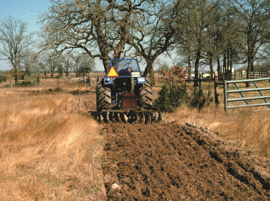 Tractor plowing a field while installing a fire break Tractor plowing a field while installing a fire break
